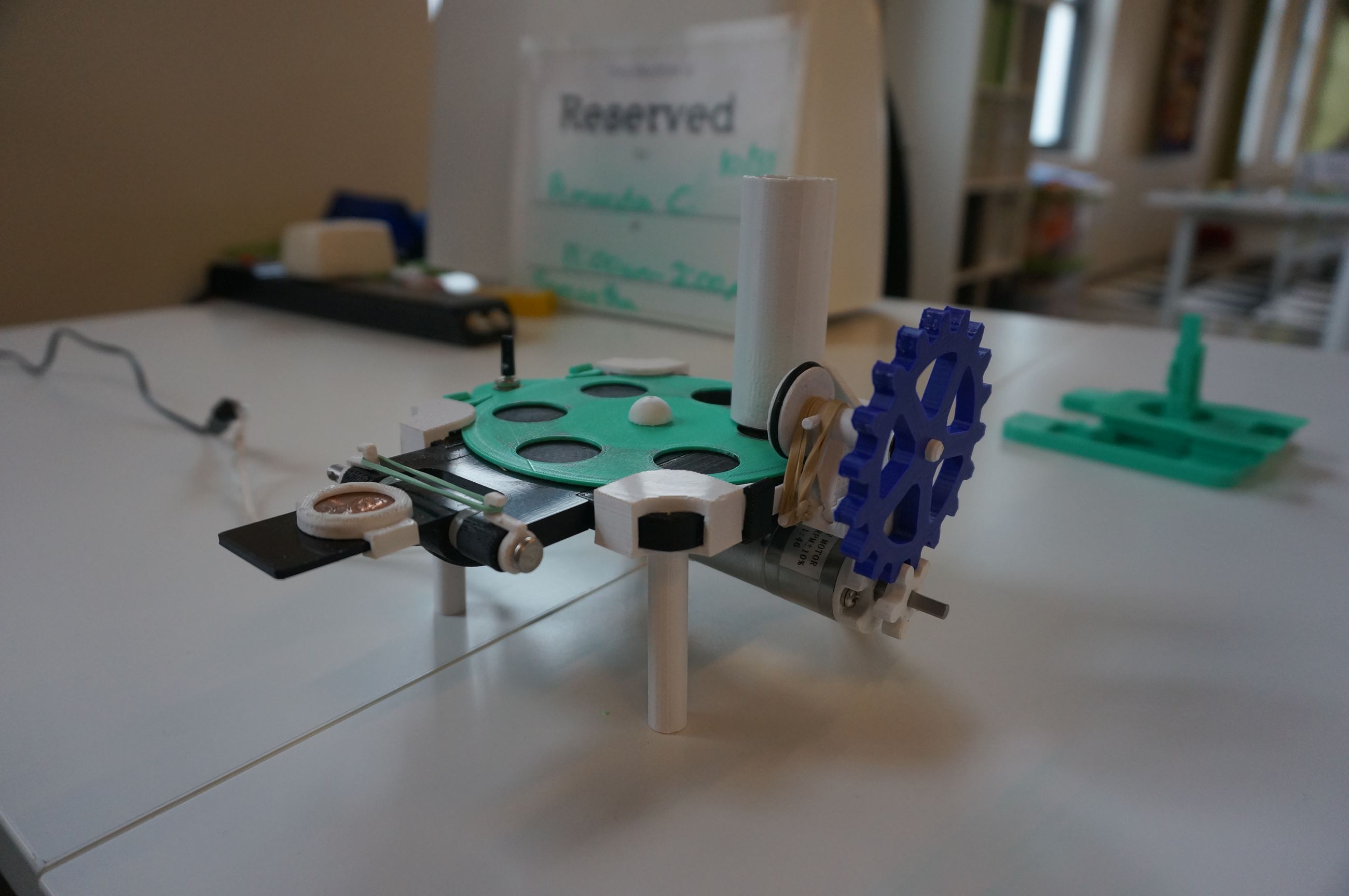 A close-up of a small machine made up of 3D printed gears and parts
