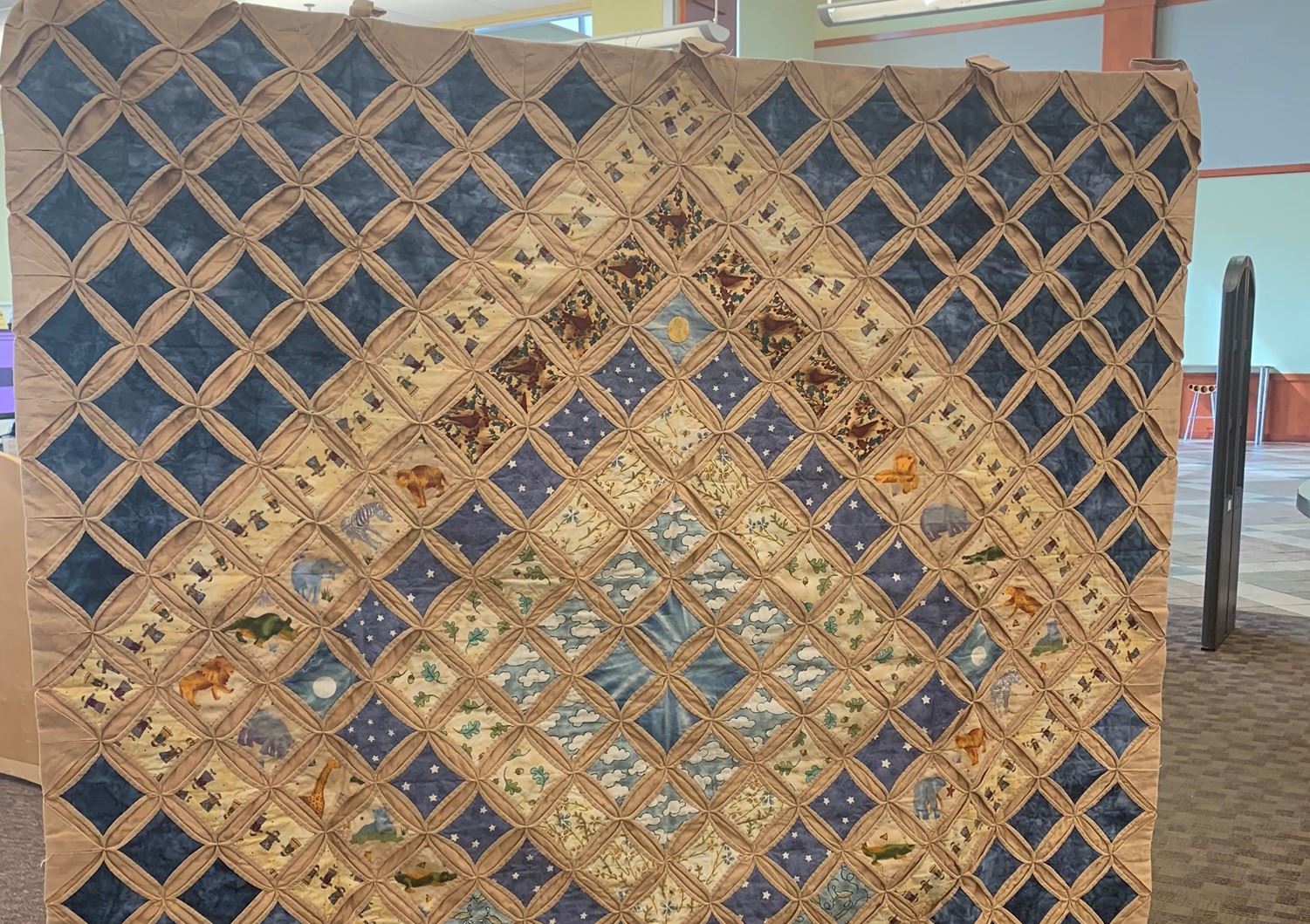 A quilt made from a series of small squares intricately placed in the shape of a diamond