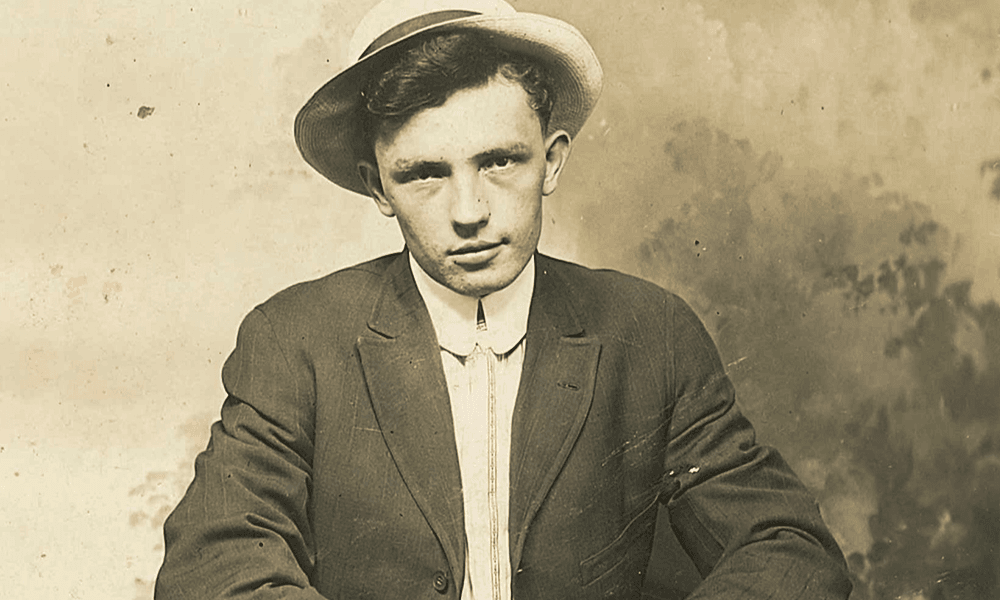 Old photo featuring a young man in a hat smirking at the camera.