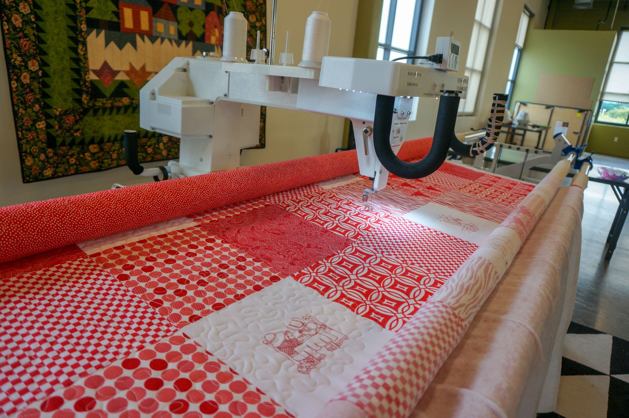 Quilting machine with bride red and white quilt